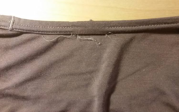 Structural threads seen from the back are cut and loose after removing the shirt tag